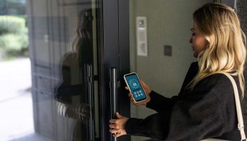 female entering secret key code for getting access and passing building using application on mobile phone, woman pressing buttons on control panel for disarming smart home system. High quality photo